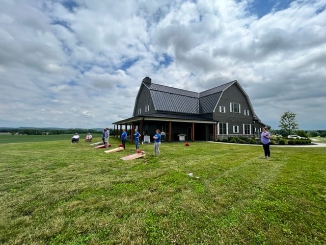 A group of people standing in front of a large house.