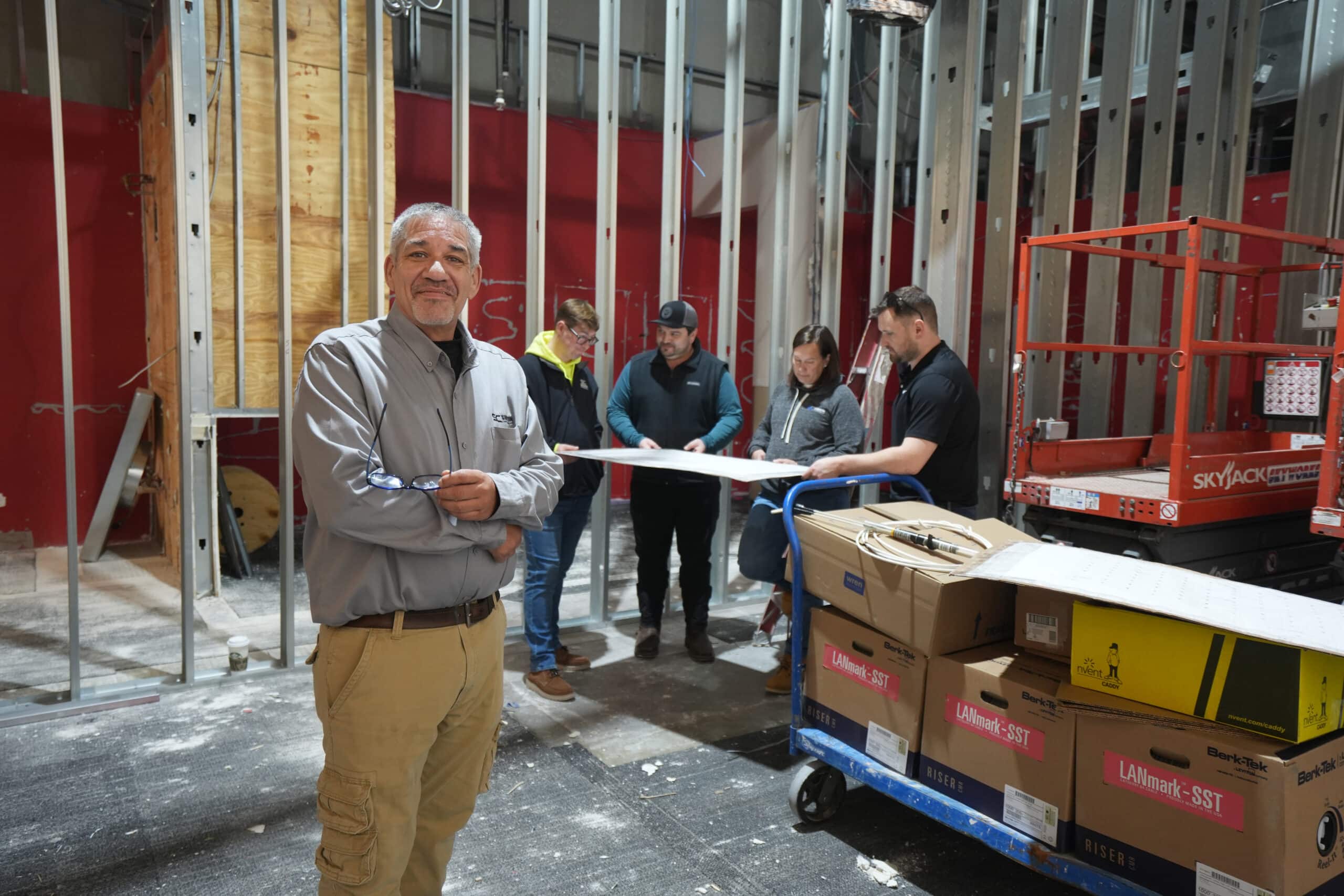 A man standing in front of boxes in a construction area.