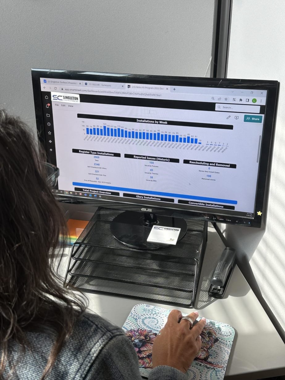 A woman sitting at a desk looking at a computer screen.